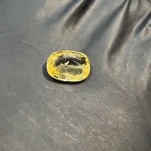 Yellow Sapphire gemstone on a dark fabric background